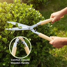 Load image into Gallery viewer, Person trimming a bush with garden shears featuring comfort classic wooden handles.